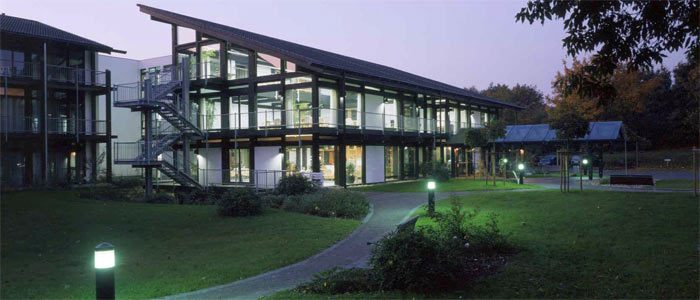 Holz-Glas-Eingangsbau des Altenpflegeheims in der Abenddämmerung
