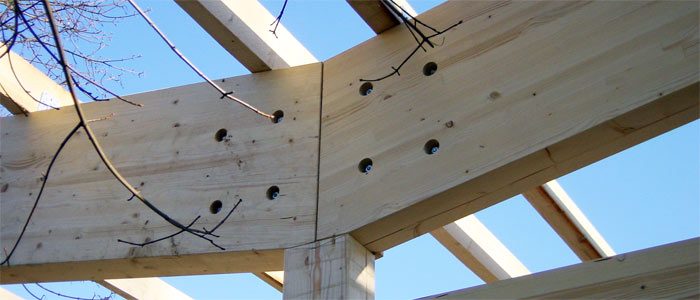 Holzbinder mit Stahlverbindern vor blauem Himmel