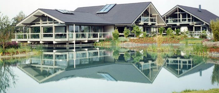 Holz-Glas-Bürohäuser, die sich in einem See spiegeln