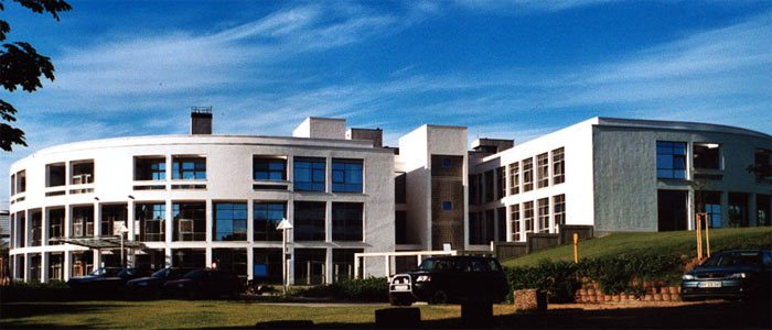 Halbrunder weißer Klinikanbau mit Fensterbändern