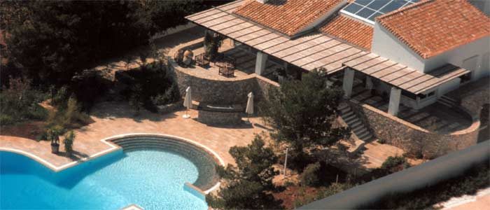 Luftaufnahme einer Villa mit geschwungenem Pool und Pergola
